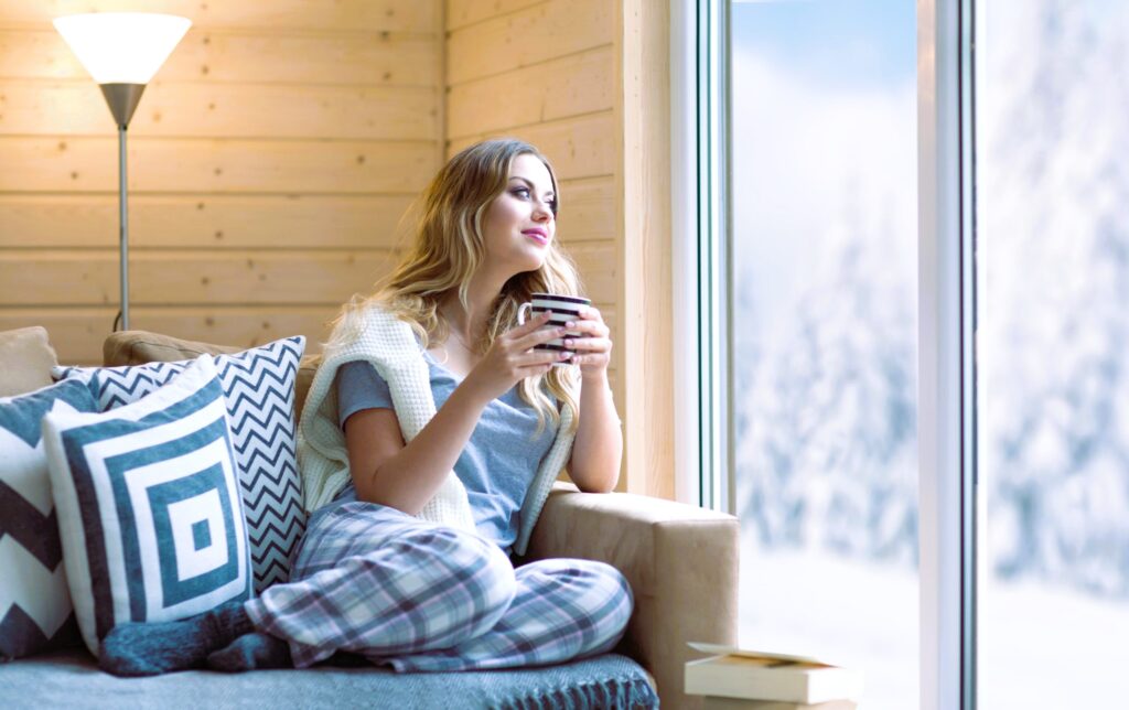 Girl in warmth admiring nature through the window